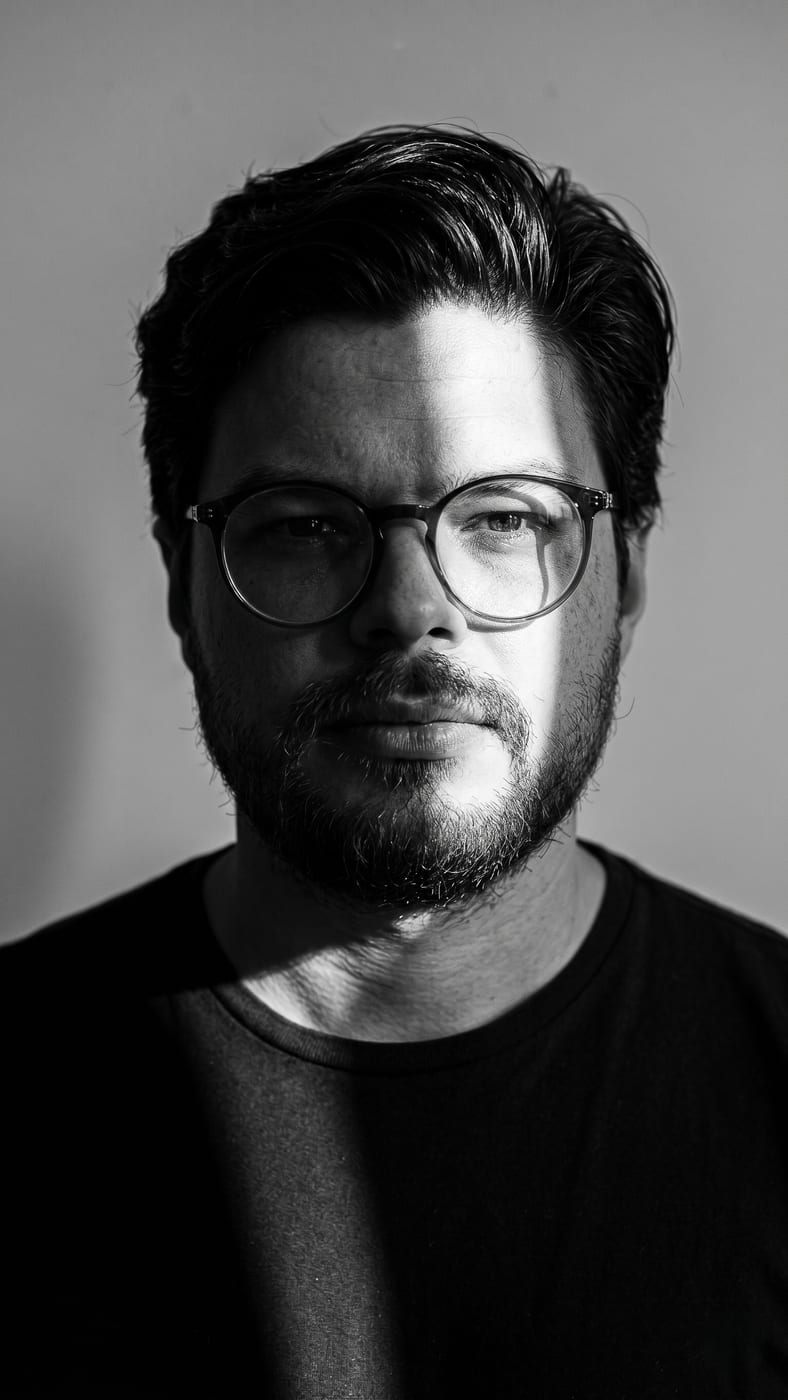 Rodrigo Campos, retrato em preto e branco com uma lâmina de luz atravessando o rosto